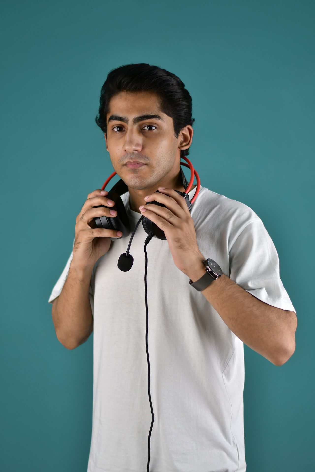 A man holding a pair of headphones to his ears